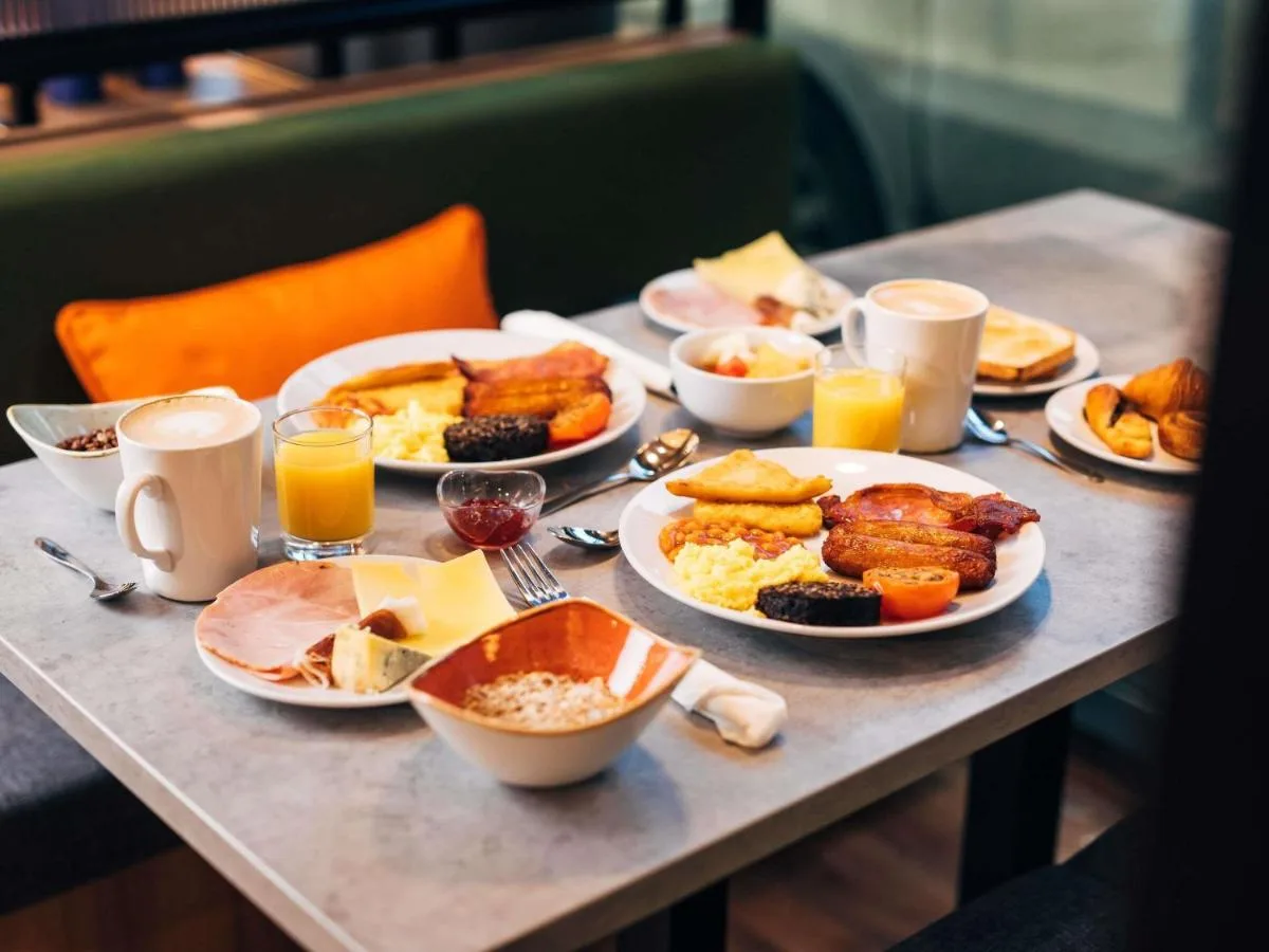 a table with plates of breakfast food on it at ibis Belfast City Centre in Belfast