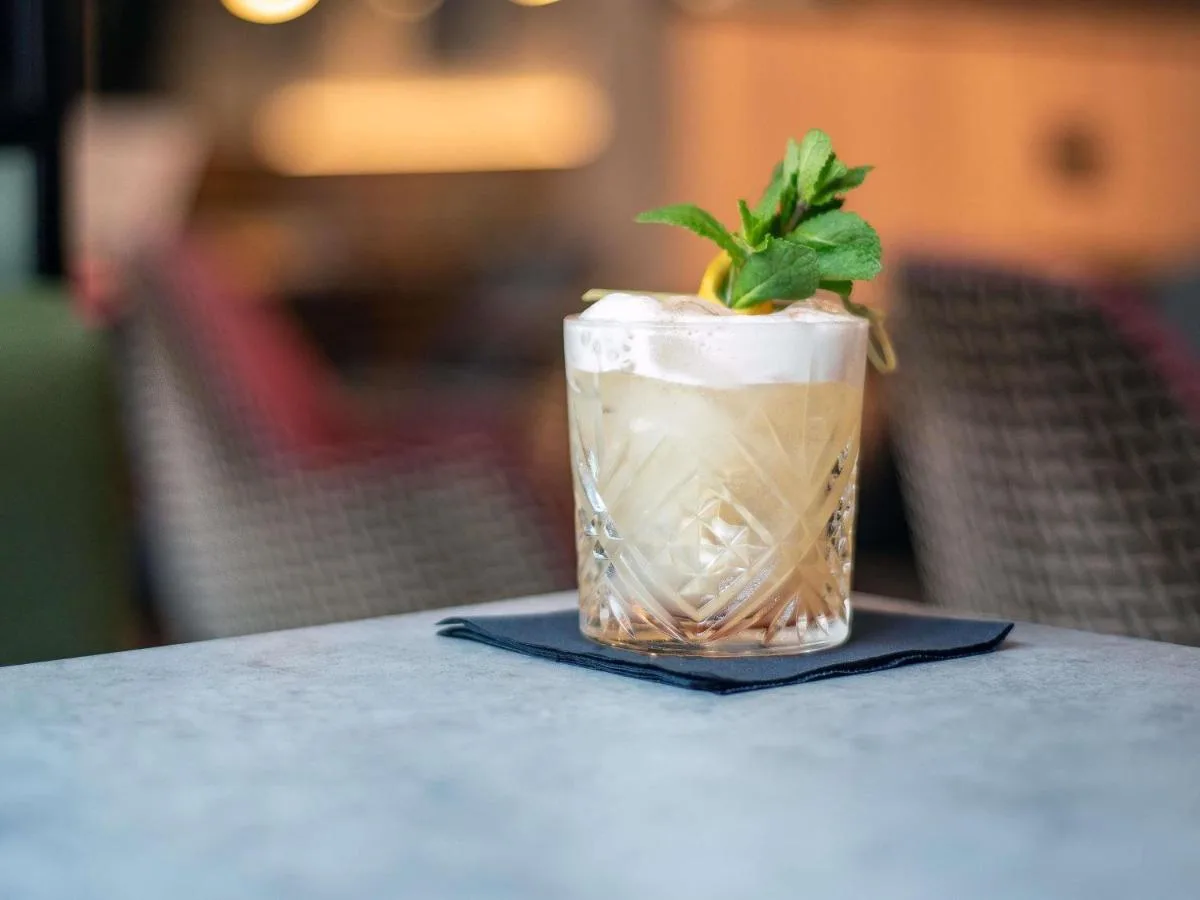 a drink with a plant in it sitting on a table at ibis Belfast City Centre in Belfast